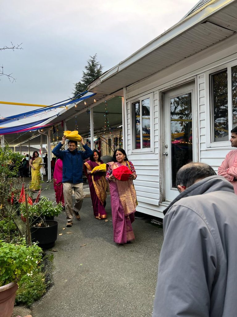 Devotees carry offerings to the puja area. 
